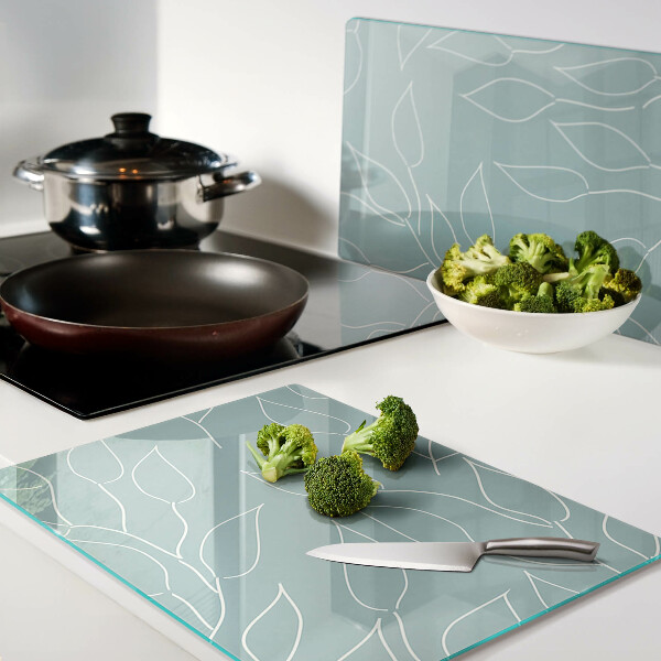 Tagliere in vetro temperato con motivo a foglie sullo sfondo