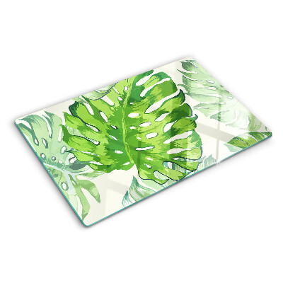 Tagliere in vetro temperato con motivo di foglie di monstera su sfondo chiaro