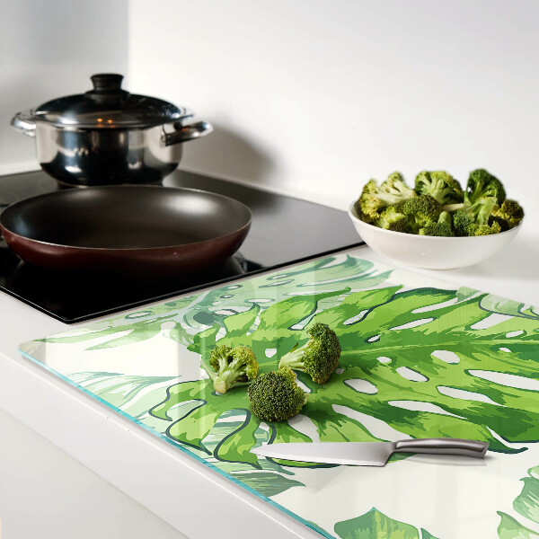 Tagliere in vetro temperato con motivo di foglie di monstera su sfondo chiaro