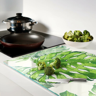 Tagliere in vetro temperato con motivo di foglie di monstera su sfondo chiaro