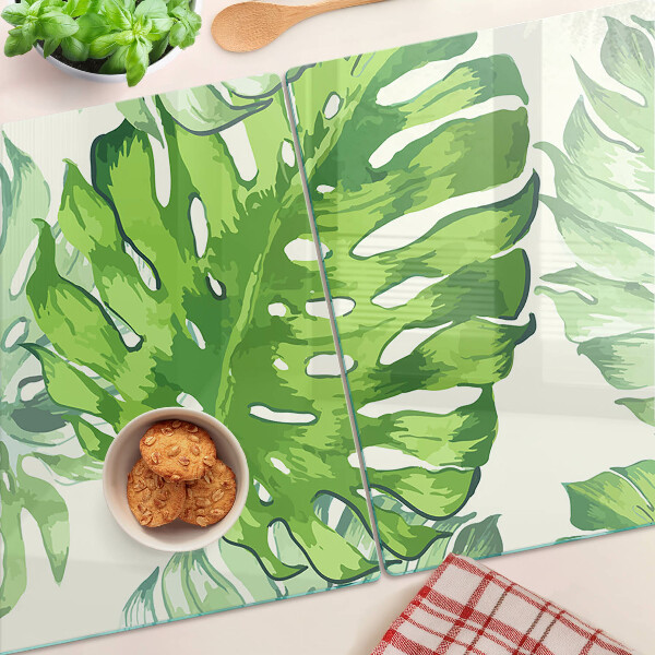 Tagliere in vetro temperato con motivo di foglie di monstera su sfondo chiaro