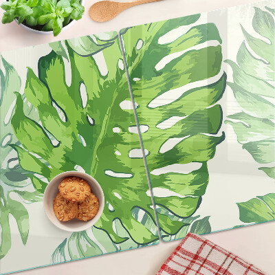 Tagliere in vetro temperato con motivo di foglie di monstera su sfondo chiaro