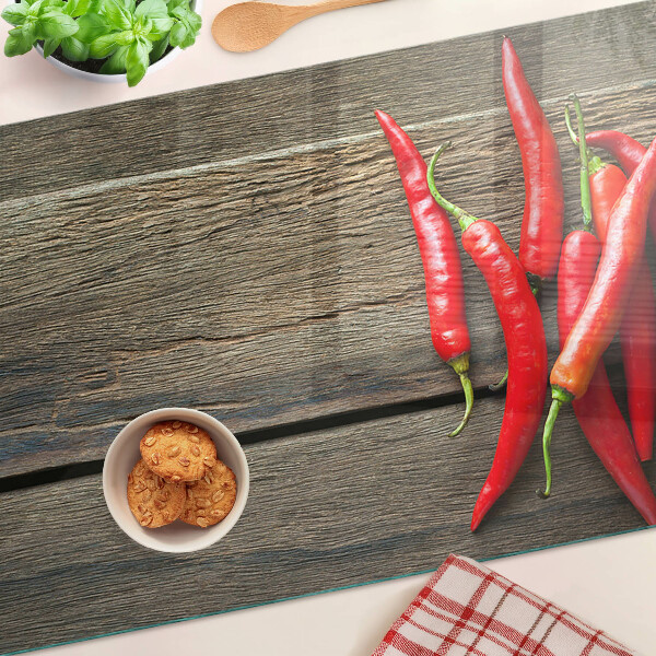 Tagliere in vetro temperato con motivo di peperoncini su sfondo di legno