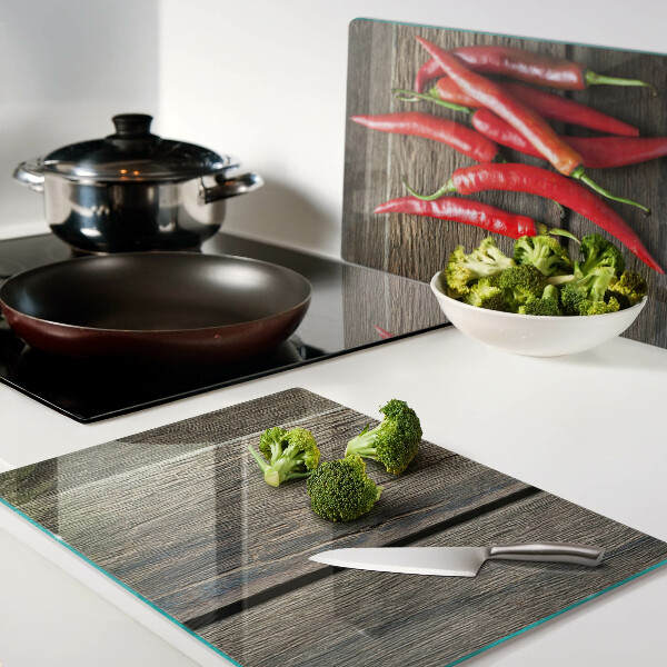 Tagliere in vetro temperato con motivo di peperoncini su sfondo di legno