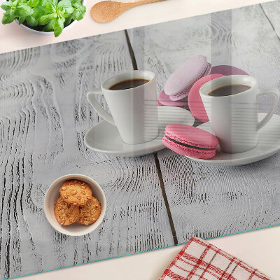 Tagliere in vetro con stampa di caffè e macaron su sfondo di legno