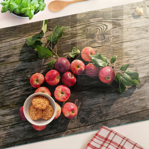Tagliere in vetro con stampa di mele su sfondo di legno
