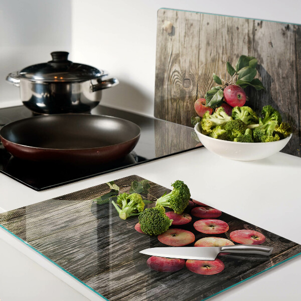 Tagliere in vetro con stampa di mele su sfondo di legno