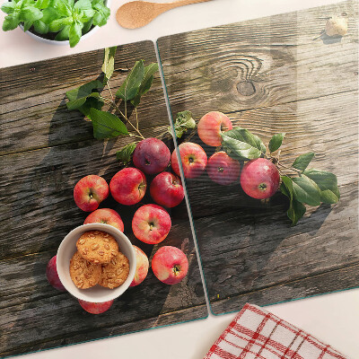 Tagliere in vetro con stampa di mele su sfondo di legno