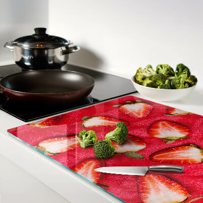 Tagliere in vetro temperato con decorazione di fragole su sfondo rosa