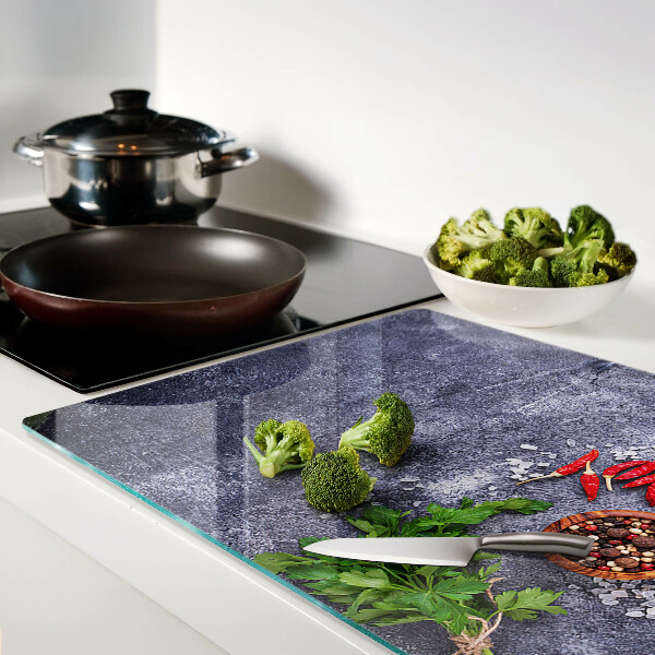 Tagliere in vetro con motivo di erbe e spezie su sfondo effetto pietra