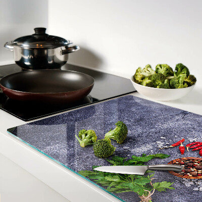 Tagliere in vetro con motivo di erbe e spezie su sfondo effetto pietra