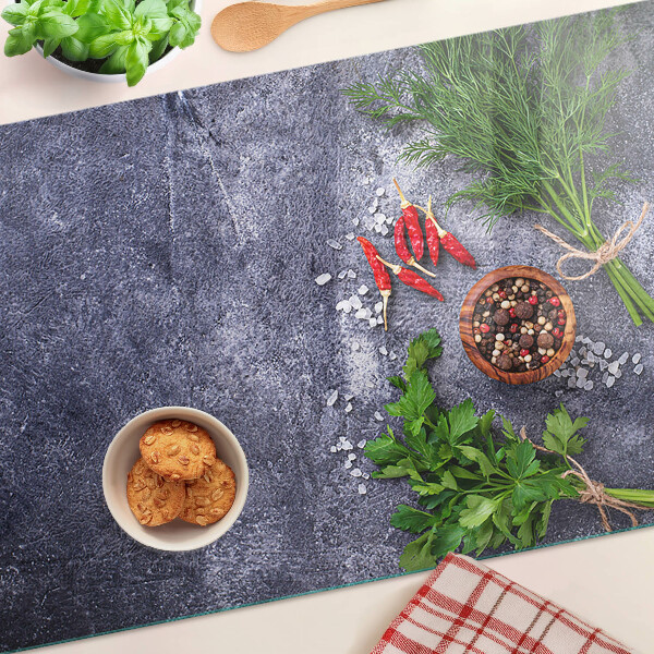 Tagliere in vetro con motivo di erbe e spezie su sfondo effetto pietra