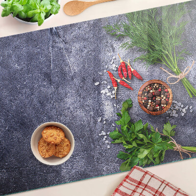 Tagliere in vetro con motivo di erbe e spezie su sfondo effetto pietra