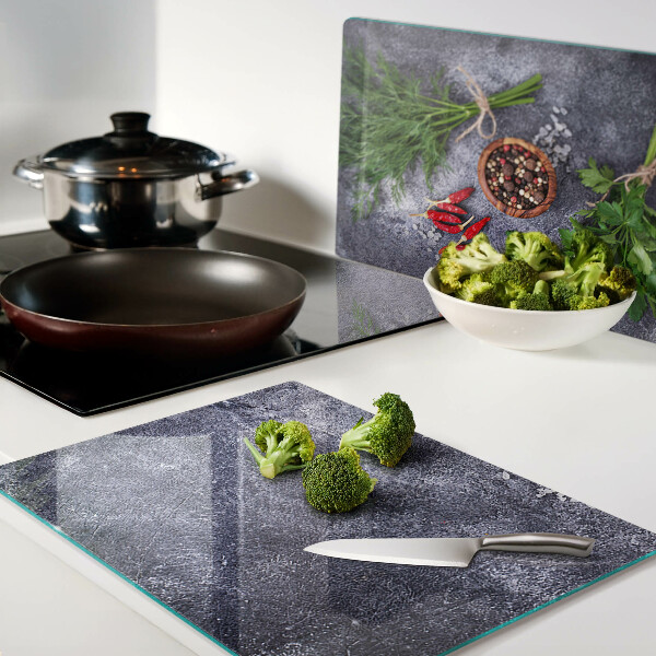 Tagliere in vetro con motivo di erbe e spezie su sfondo effetto pietra