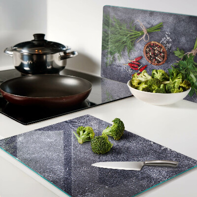 Tagliere in vetro con motivo di erbe e spezie su sfondo effetto pietra