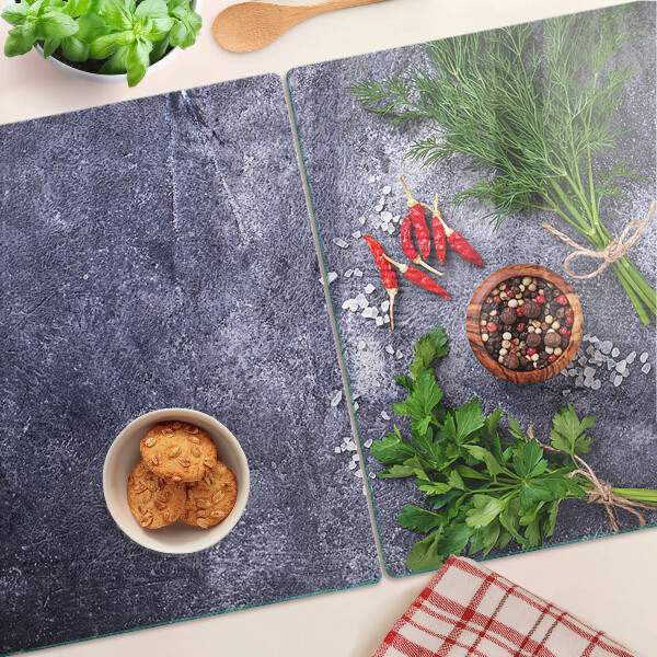 Tagliere in vetro con motivo di erbe e spezie su sfondo effetto pietra