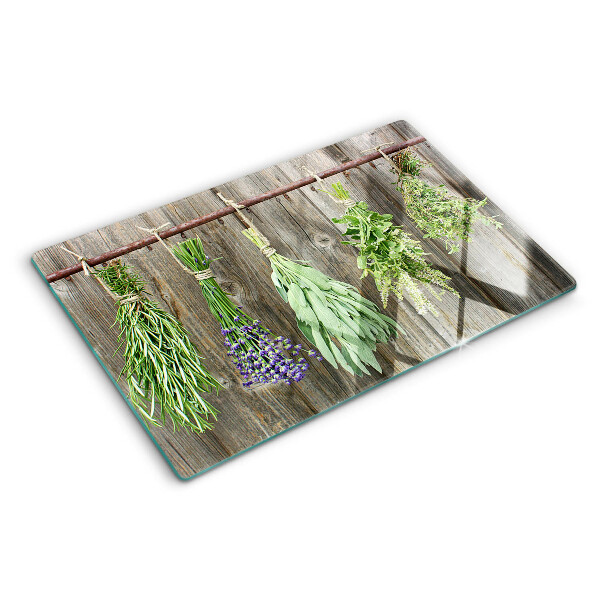 Tagliere in vetro con stampa di erbe su sfondo di legno