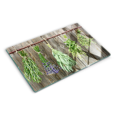 Tagliere in vetro con stampa di erbe su sfondo di legno