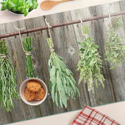 Tagliere in vetro con stampa di erbe su sfondo di legno