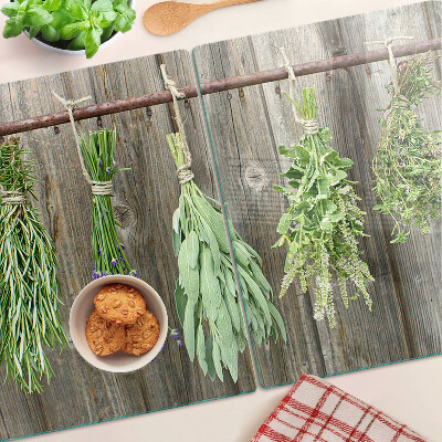 Tagliere in vetro con stampa di erbe su sfondo di legno