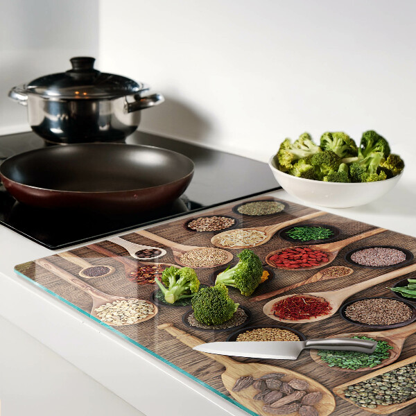 Tagliere in vetro temperato con motivo di spezie ed erbe rappresentate su cucchiai