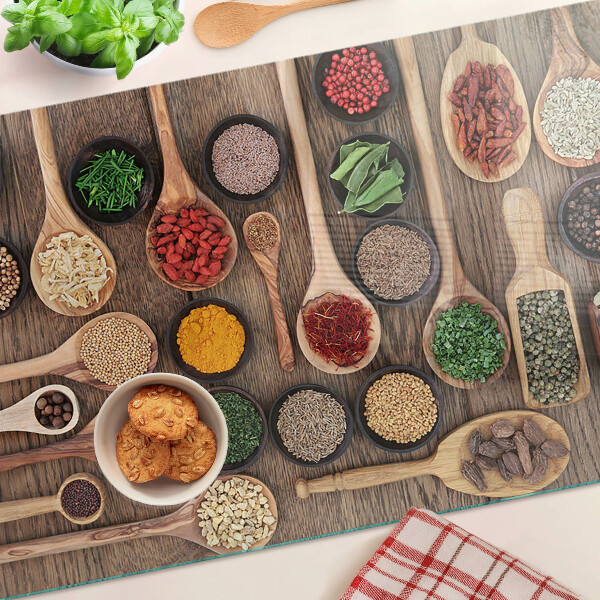 Tagliere in vetro temperato con motivo di spezie ed erbe rappresentate su cucchiai