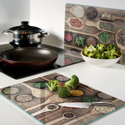 Tagliere in vetro temperato con motivo di spezie ed erbe rappresentate su cucchiai