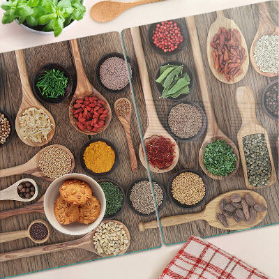 Tagliere in vetro temperato con motivo di spezie ed erbe rappresentate su cucchiai