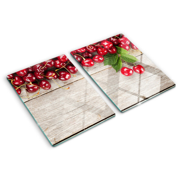 Tagliere in vetro con stampa di ciliegie su sfondo di legno