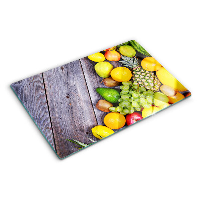Tagliere in vetro con stampa di frutta su sfondo di legno