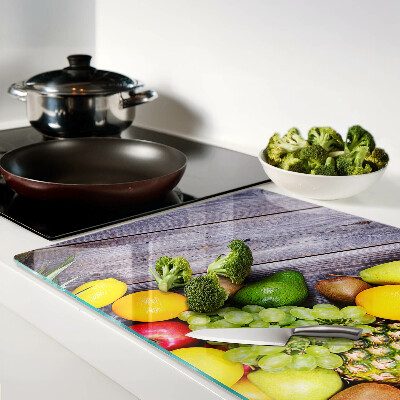 Tagliere in vetro con stampa di frutta su sfondo di legno