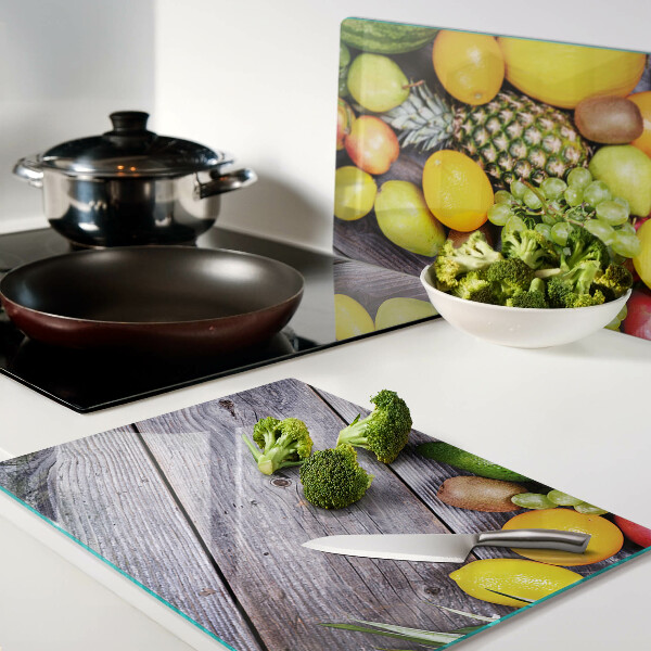 Tagliere in vetro con stampa di frutta su sfondo di legno