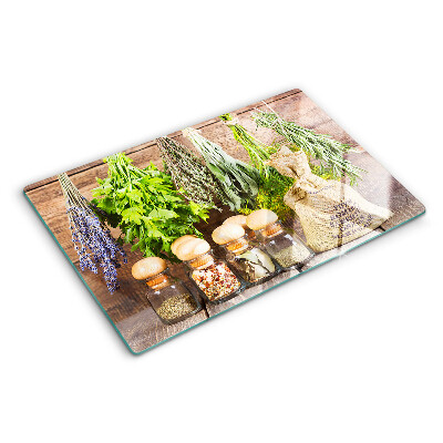 Tagliere in vetro con stampa di erbe e spezie su sfondo di legno