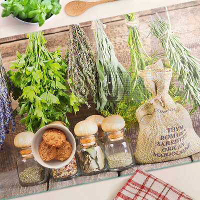 Tagliere in vetro con stampa di erbe e spezie su sfondo di legno