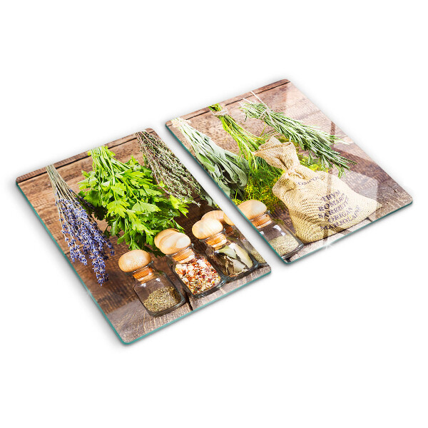 Tagliere in vetro con stampa di erbe e spezie su sfondo di legno