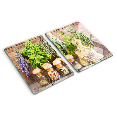 Tagliere in vetro con stampa di erbe e spezie su sfondo di legno