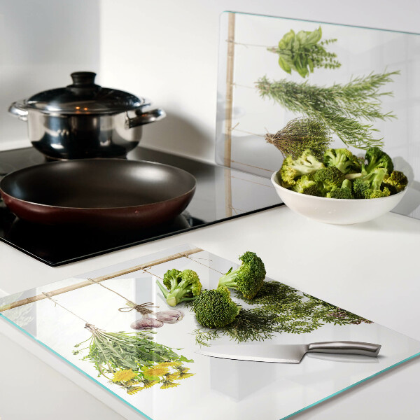 Tagliere in vetro temperato con decorazione di erbe disposte a mazzetti appesi