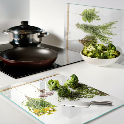 Tagliere in vetro temperato con decorazione di erbe disposte a mazzetti appesi