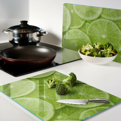 Tagliere in vetro temperato Fette di lime su sfondo verde