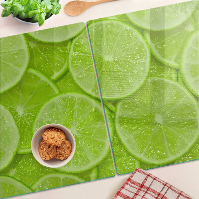 Tagliere in vetro temperato Fette di lime su sfondo verde