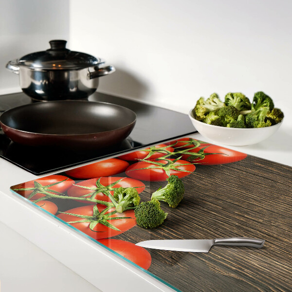 Tagliere in vetro con stampa di pomodori su sfondo di legno