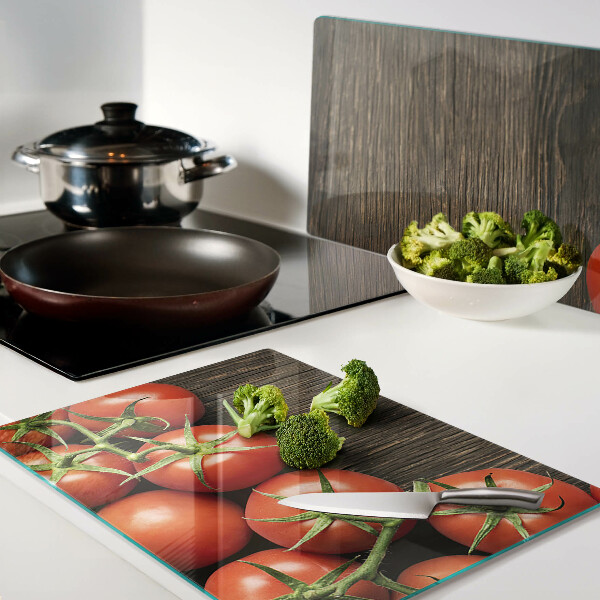 Tagliere in vetro con stampa di pomodori su sfondo di legno