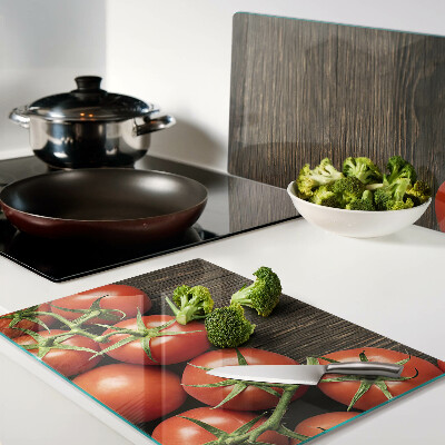 Tagliere in vetro con stampa di pomodori su sfondo di legno