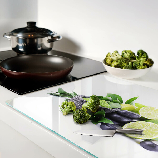 Tagliere in vetro con motivo di limoni e uva su sfondo verde