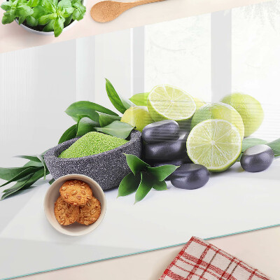 Tagliere in vetro con motivo di limoni e uva su sfondo verde