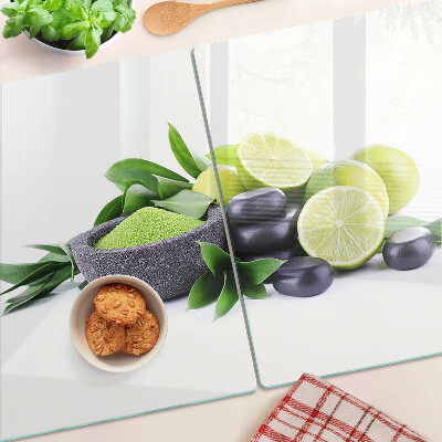 Tagliere in vetro con motivo di limoni e uva su sfondo verde