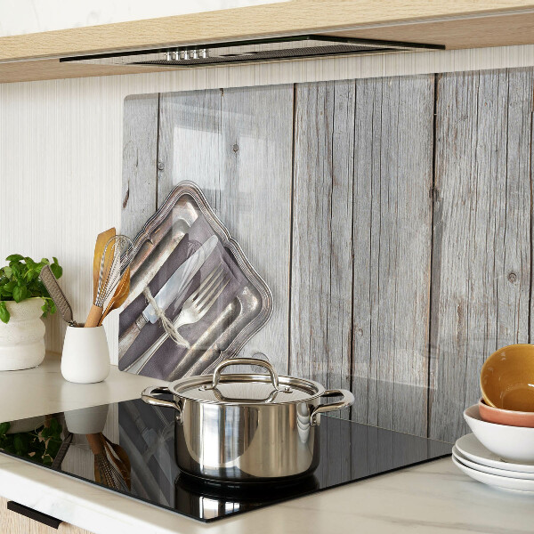 Tagliere in vetro con posate rustiche su sfondo di legno