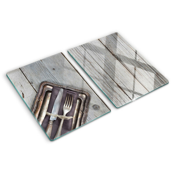 Tagliere in vetro con posate rustiche su sfondo di legno