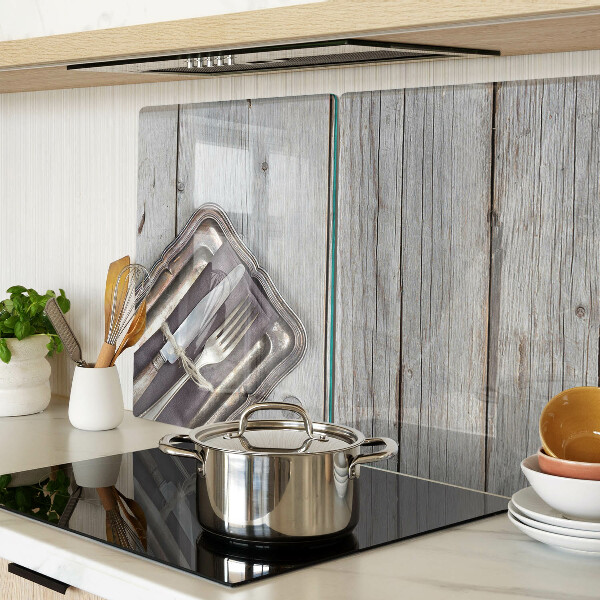 Tagliere in vetro con posate rustiche su sfondo di legno