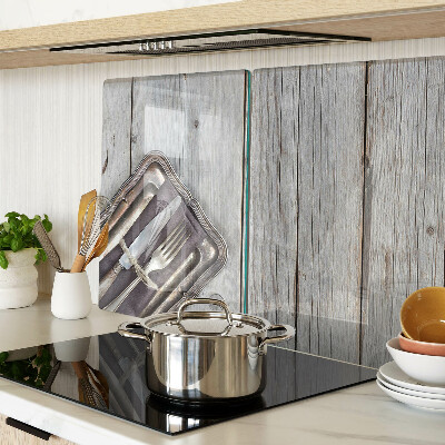 Tagliere in vetro con posate rustiche su sfondo di legno